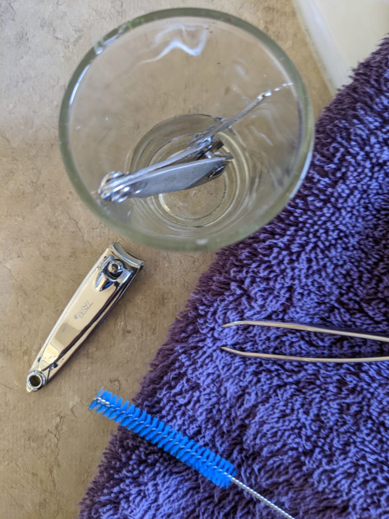 Nail clippers & tweezers soaking in hydrogen peroxide